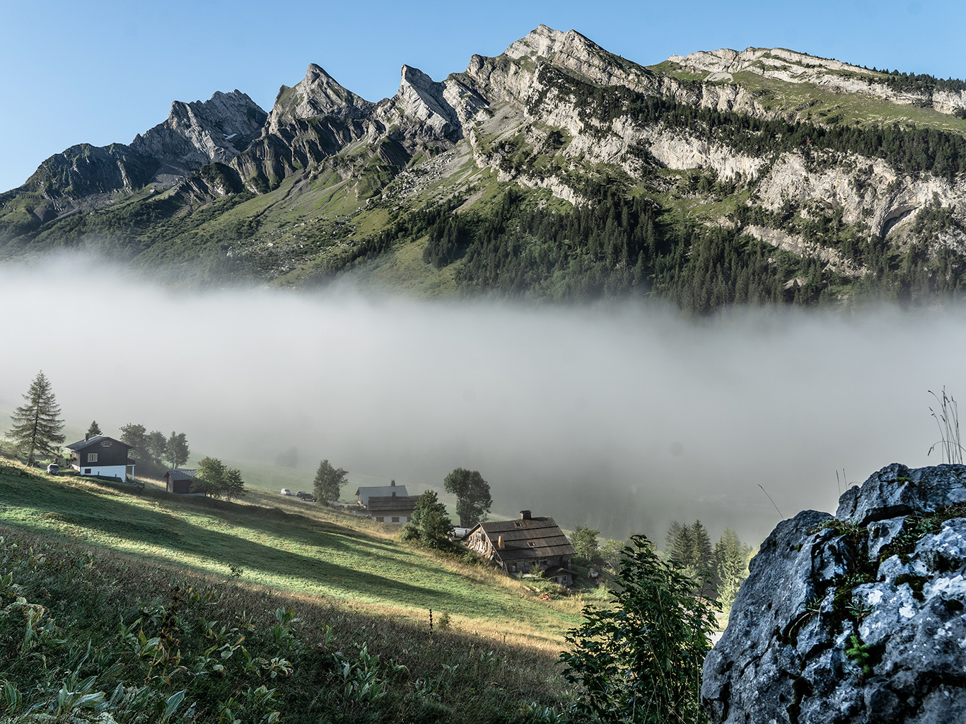 Ranní mlha, která se drží v údolí pod vápencovým masivem Aravis