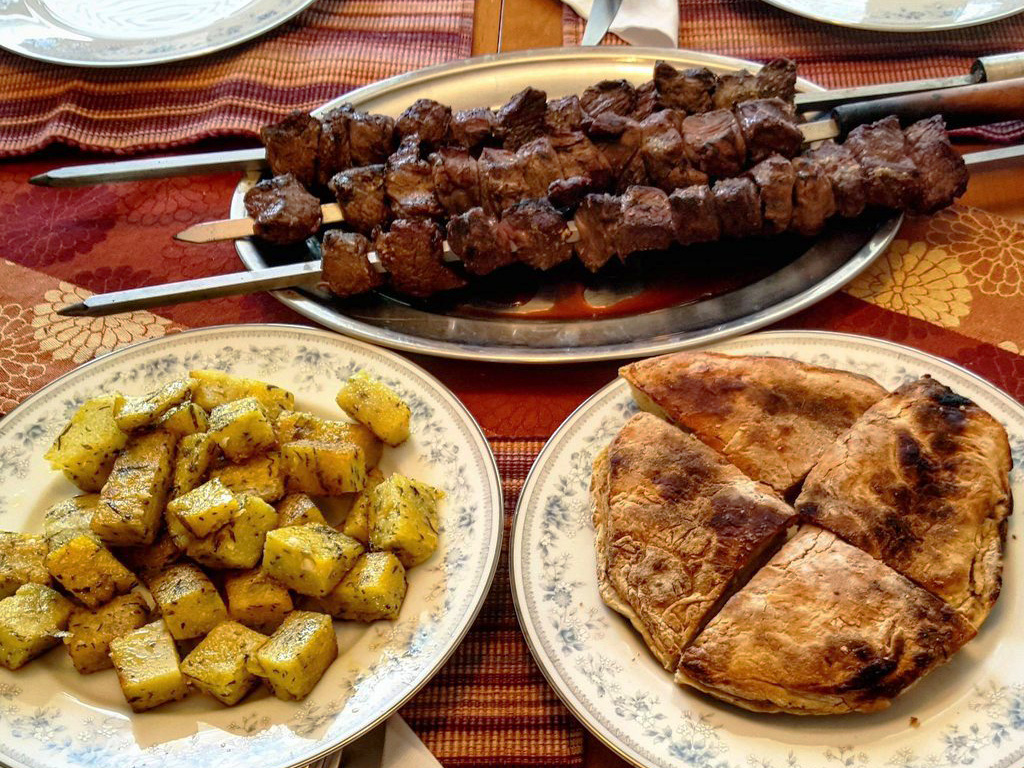 Špízy zvané espetada doprovázené milho frito a bolo de caco