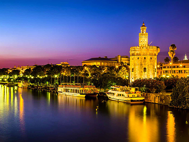 Sevillu chrání strážní věž Torre de Oro u řeky Guadalquivir