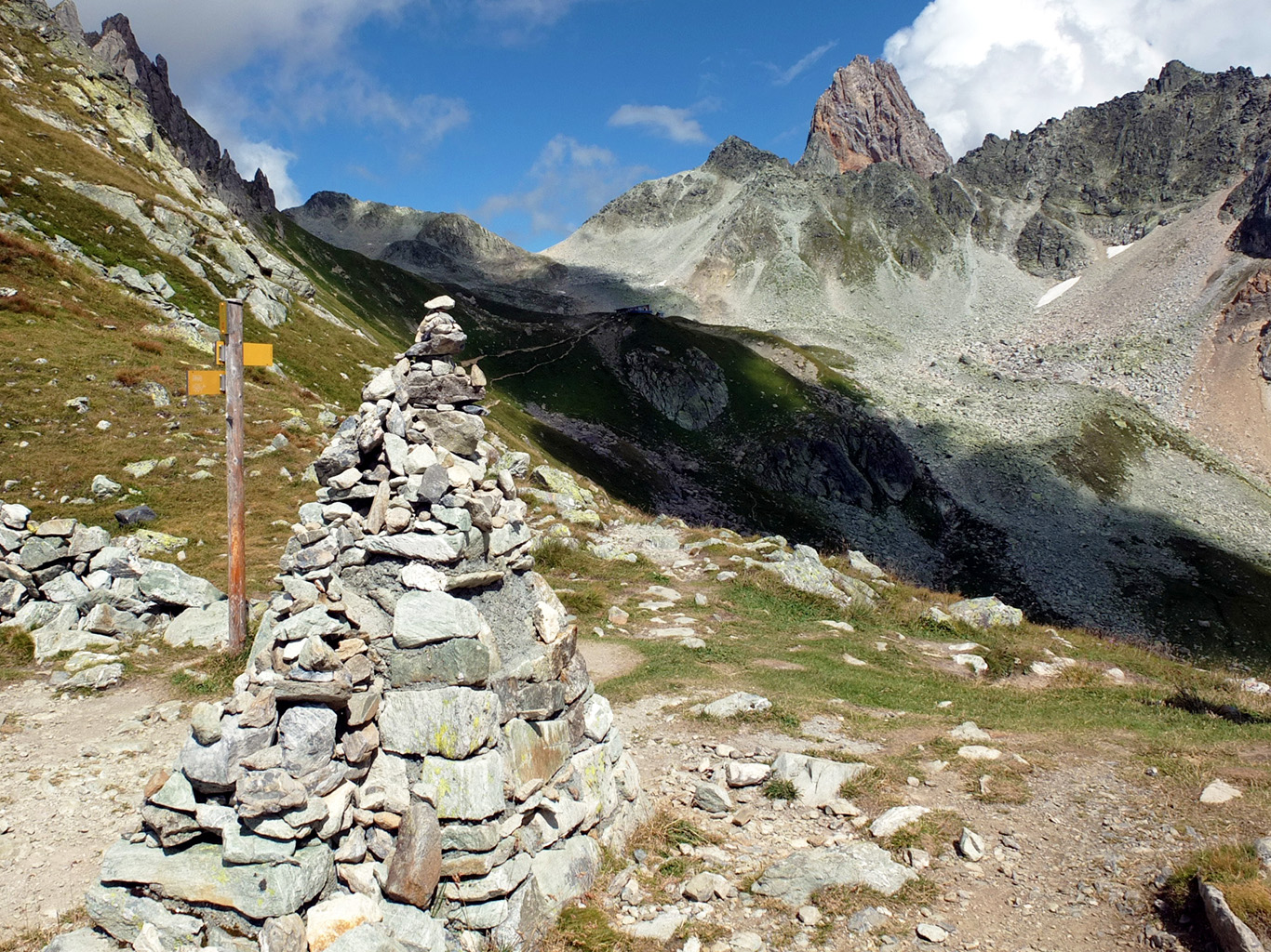 Rozcestník a velký kamenný mužík v sedle Col de Bresson