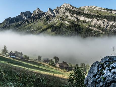 Ranní mlha, která se drží v údolí pod vápencovým masivem Aravis