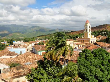 Střechy ospalého Trinidadu s pohořím Sierra del Escambray na dohled