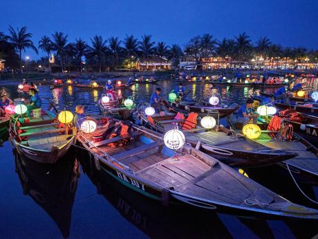 V Hoi An brázdí po setmění po řece Thu Bon loďky osvětlené lampióny